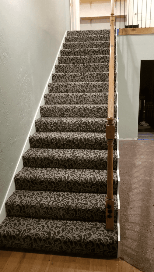 Staircase carpeted in a patterned carpet with matched pattern on every step