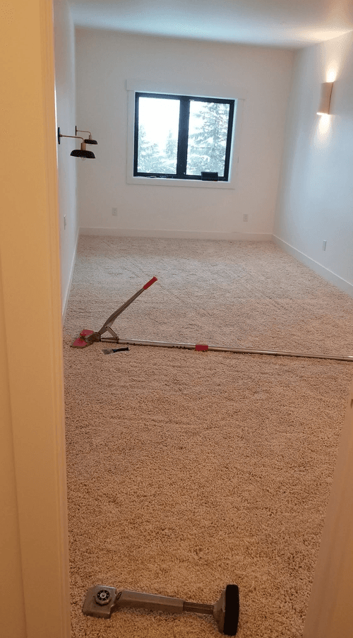 Newly carpeted room with carpet stretching tools on the floor