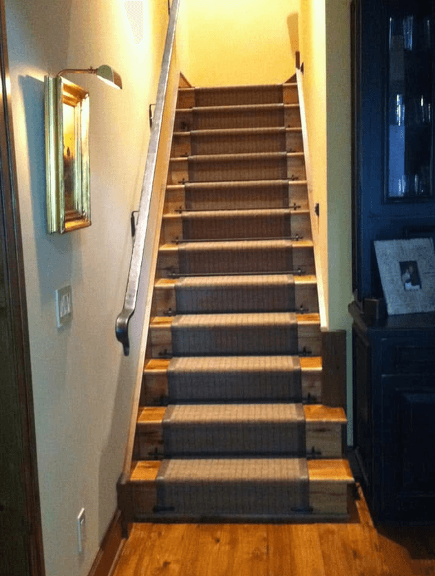 Straight staircase with carpeted treads framed by contrasting wood edges