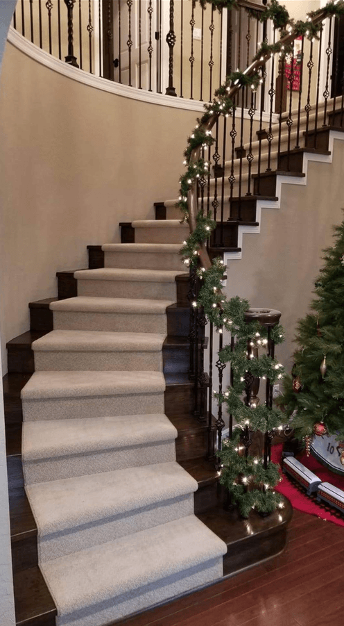 Curved staircase with light carpet treads and dark wood edges